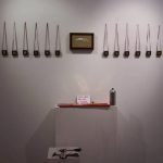 una serie di tavolette attaccate in fila, un'installazione all'interno della mostra